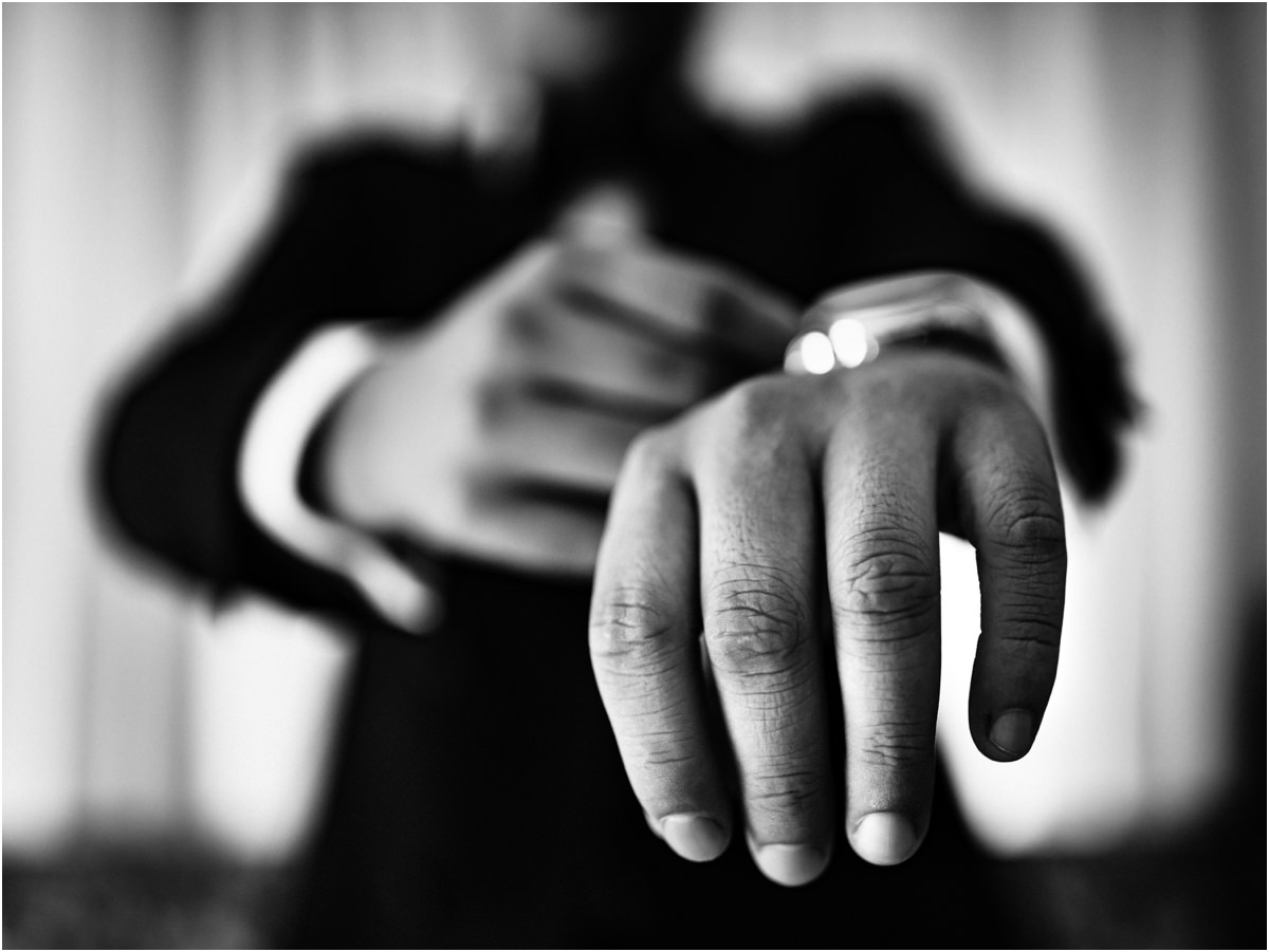 Dettaglio in bianco e nero della mano dello sposo con l'anello