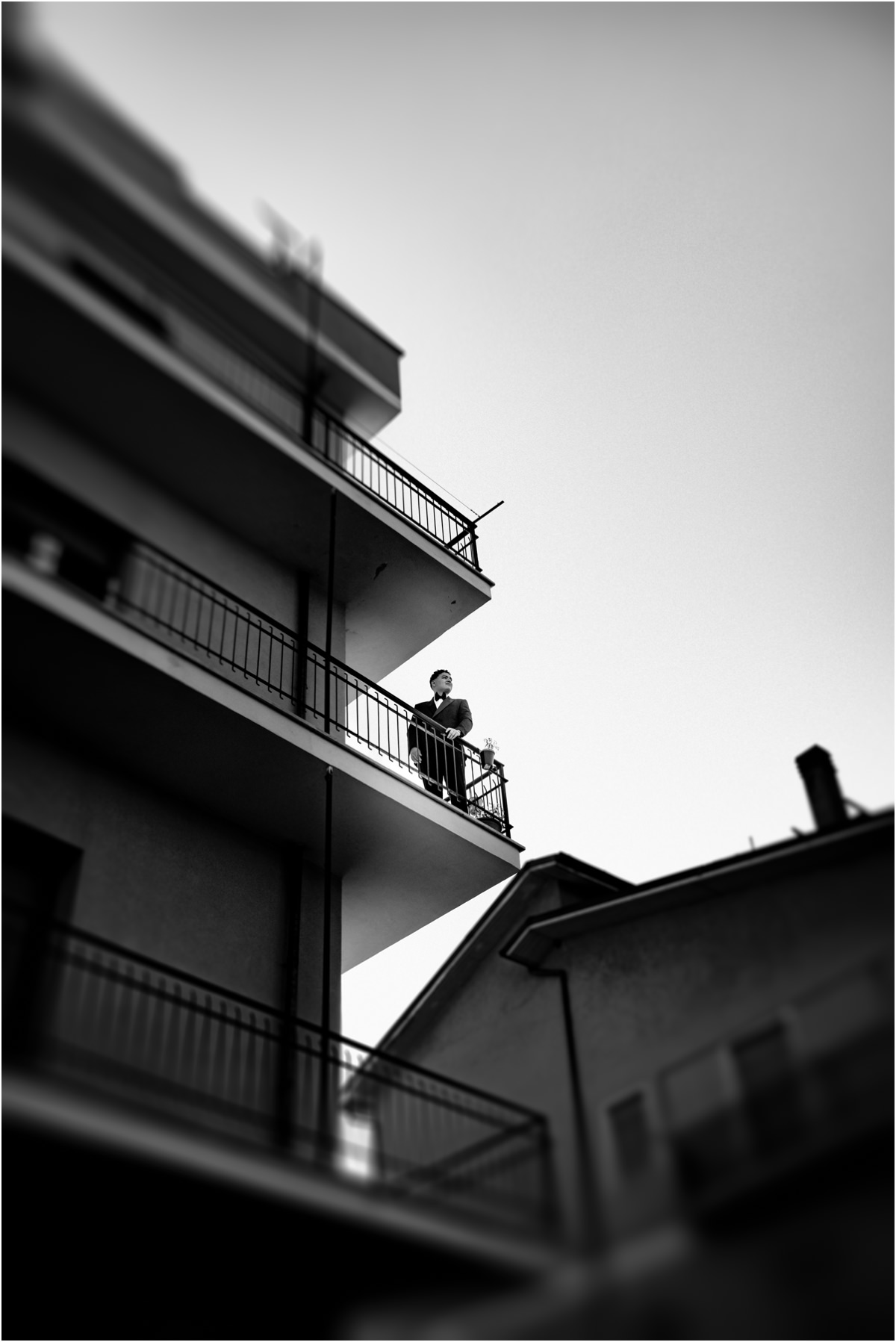 Foto in bianco e nero dal basso del palazzo con lo sposo sul balcone a Poggio Moiano