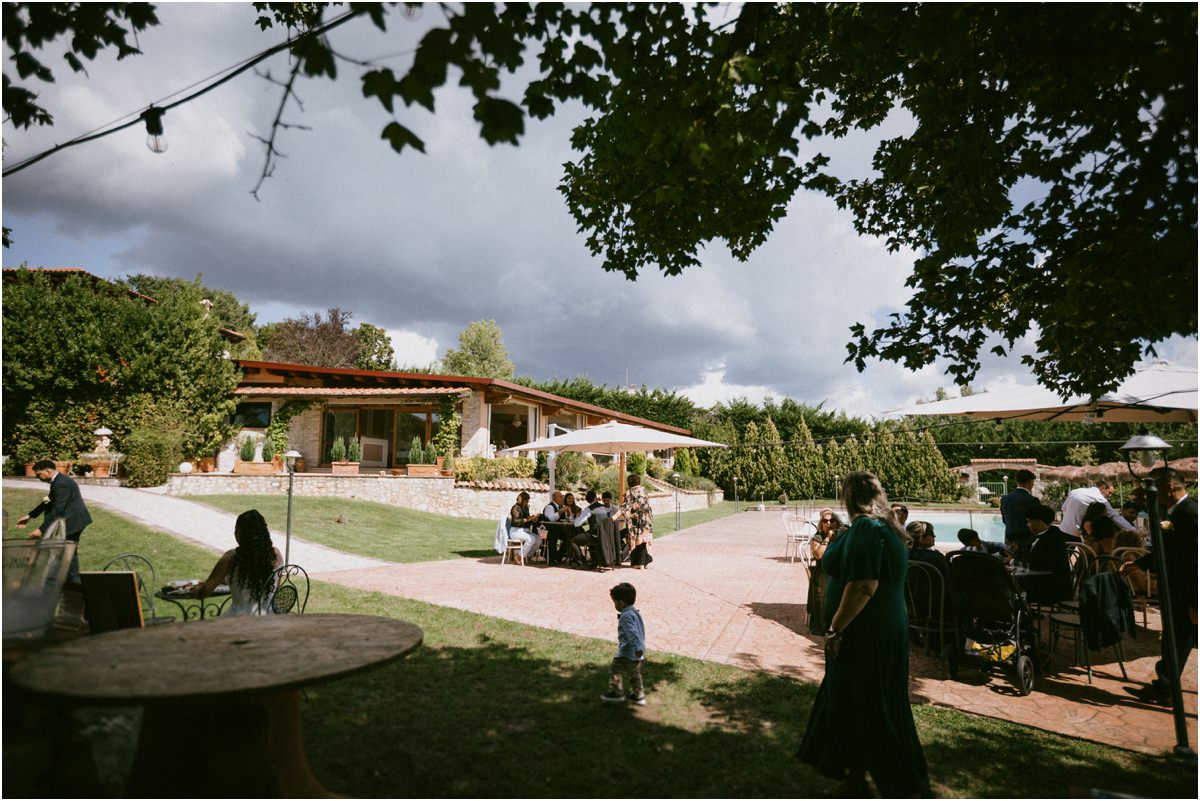 Il giardino della Tenuta La Ginestra con ospiti e ombrelloni durante il ricevimento in Sabina