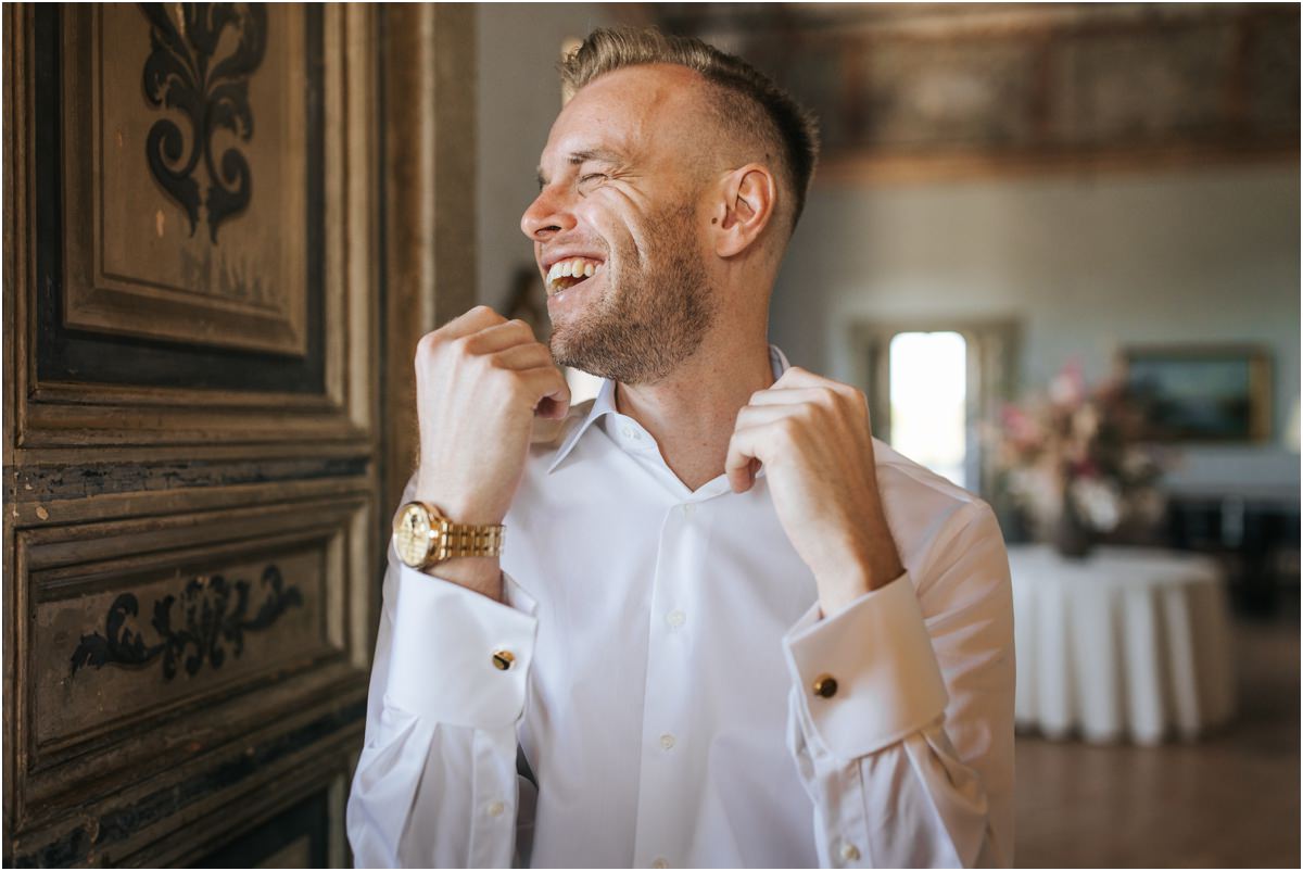 Groom Angus Laughing, Cufflinks and Gold Watch Groom Angus laughing while adjusting his shirt collar, wearing cufflinks and a gold watch, Villa Grazioli