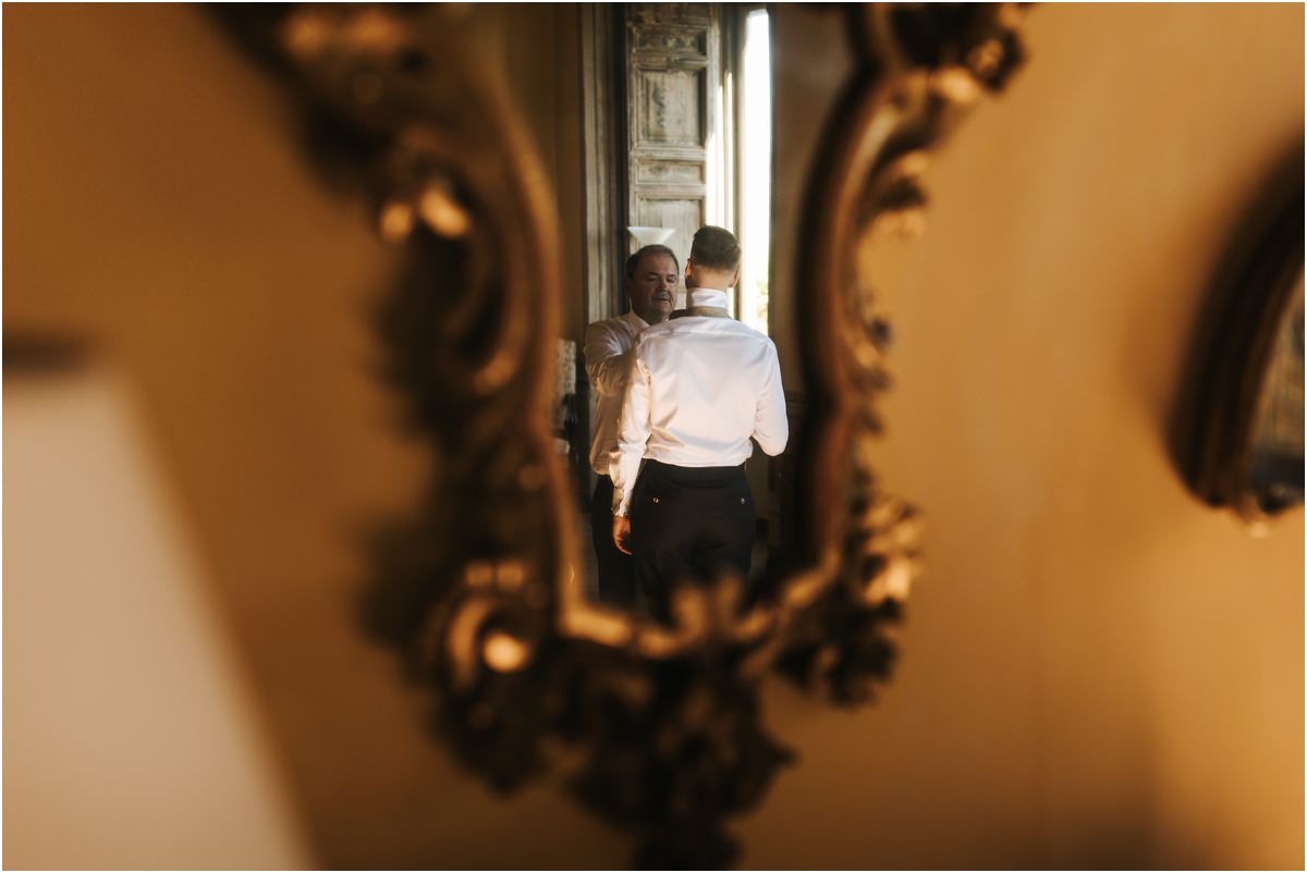 Groom Reflected in a Baroque Mirror Groom Angus and a family member reflected in an ornate gold mirror at Villa Grazioli