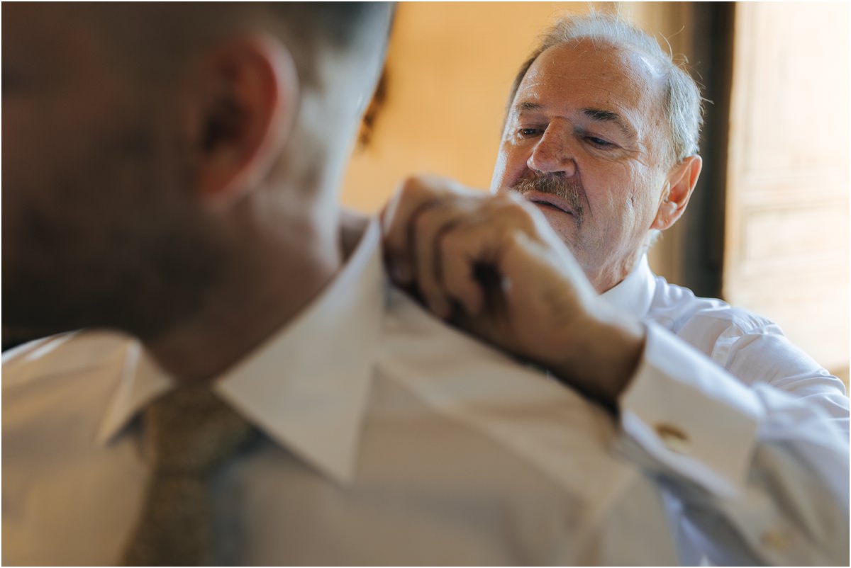 Family Member Fixing the Groom Collar Older man carefully fixing the shirt collar of groom Angus at Villa Grazioli
