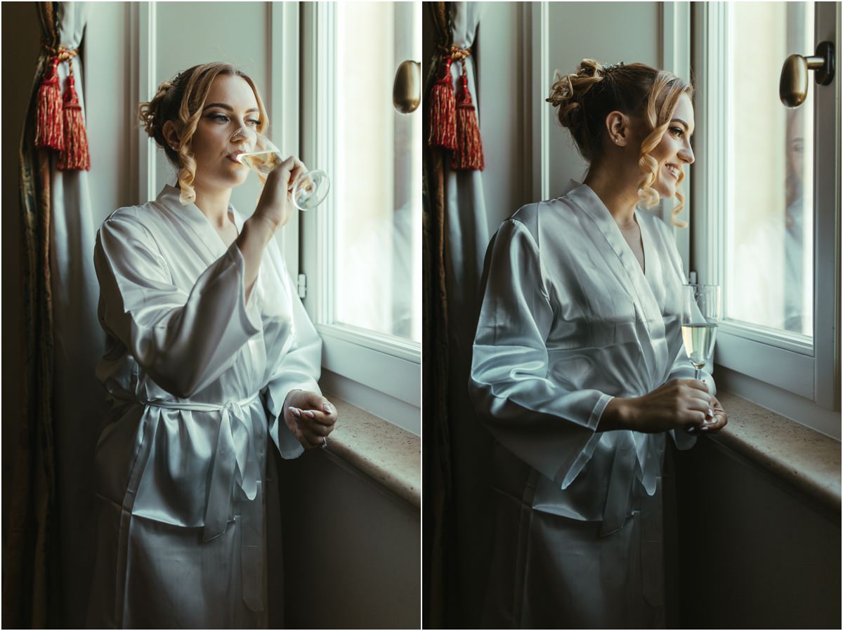 Bride with Champagne by the Window Bride Miriana in a satin robe sipping champagne and looking out of the window