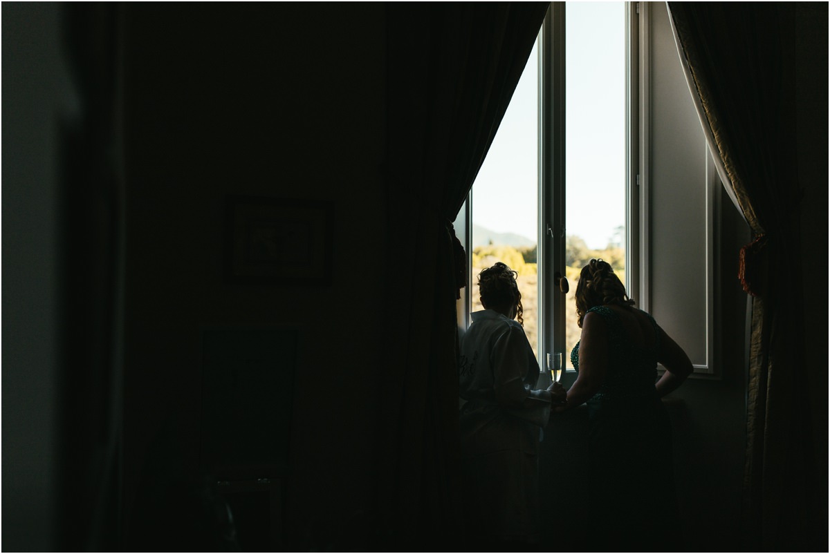 Silhouettes by the Window Silhouettes of two people sitting by a bright window in a dark room during the bride preparations