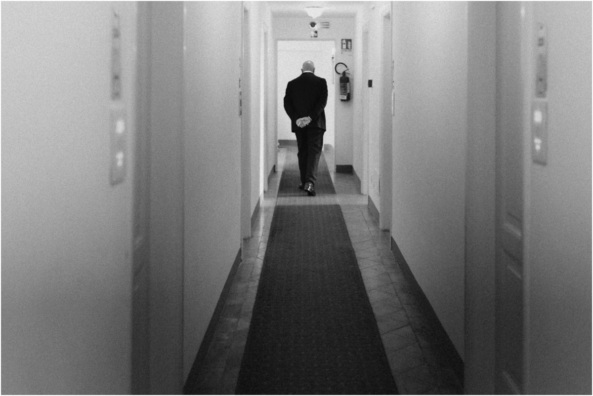Walking Down the Corridor, Black and White Black and white photo of a man in a tuxedo walking away down a long corridor