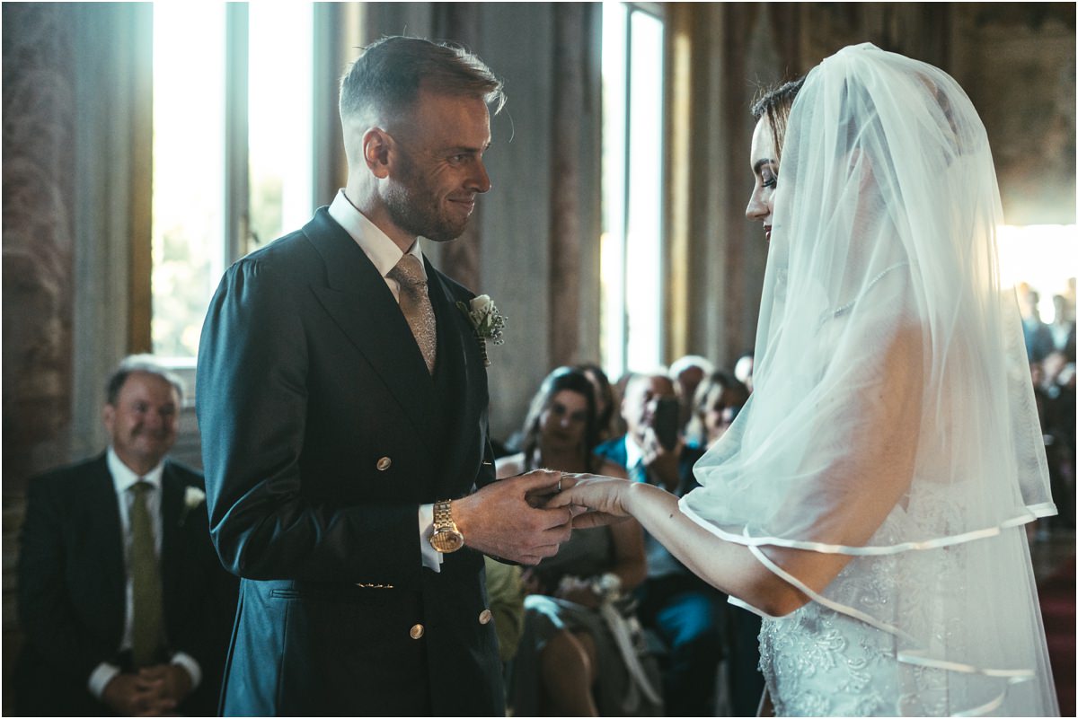 Exchange of Rings at Villa Grazioli Emotional groom Angus placing the wedding ring on the finger of bride Miriana at Villa Grazioli