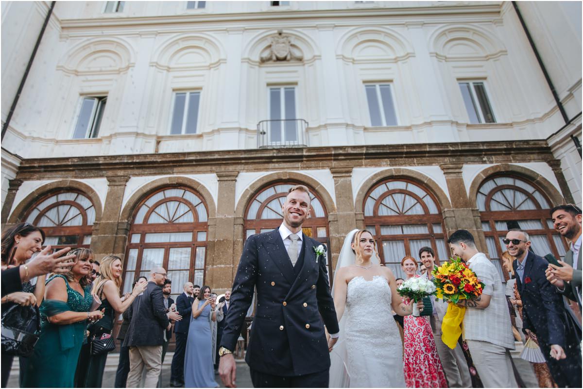 Newlyweds Celebrated Outside Villa Grazioli Miriana and Angus walking out in front of the facade of Villa Grazioli while guests cheer and celebrate