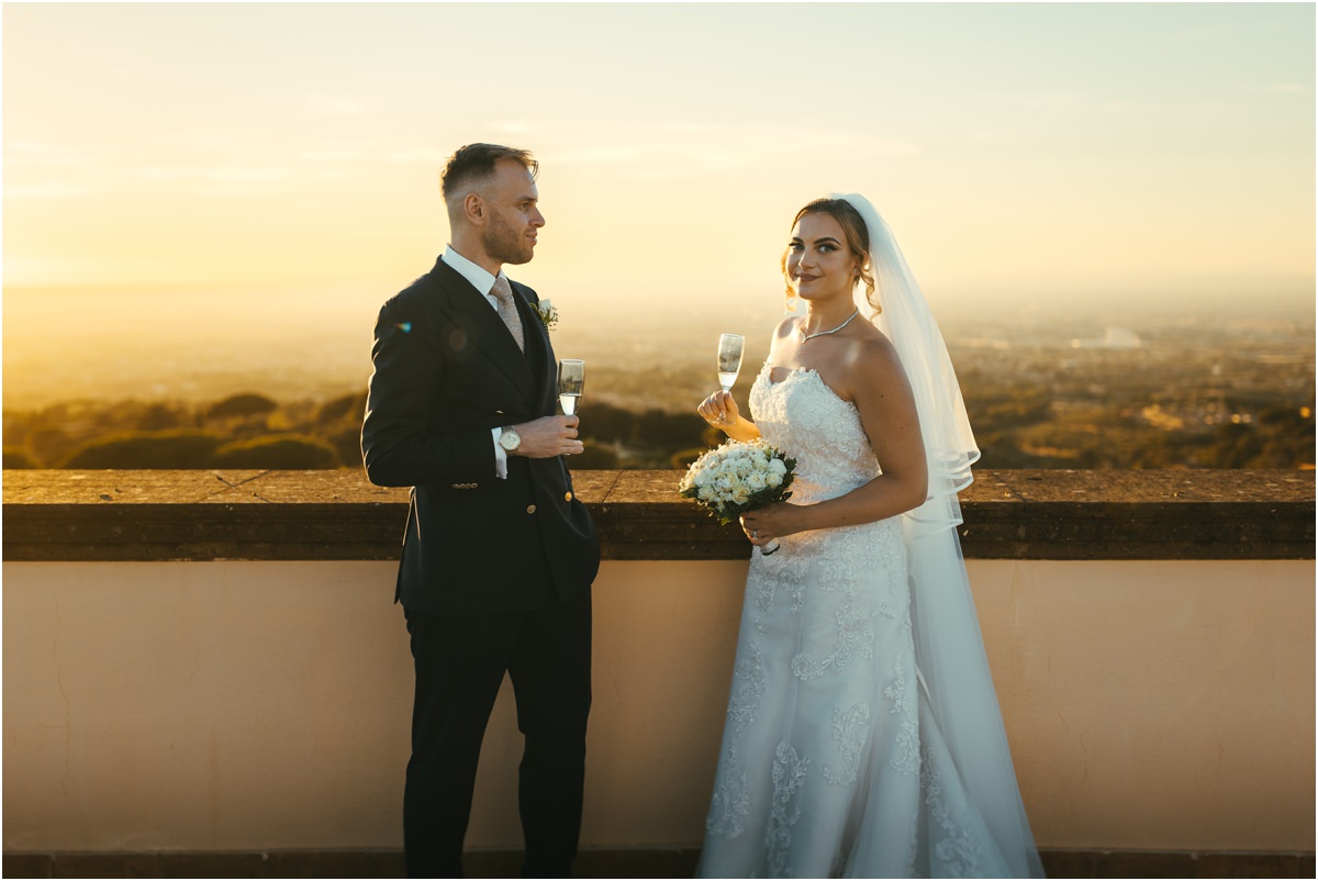 Newlyweds Toasting on the Terrace Miriana and Angus holding glasses of champagne on the terrace of Villa Grazioli in golden light