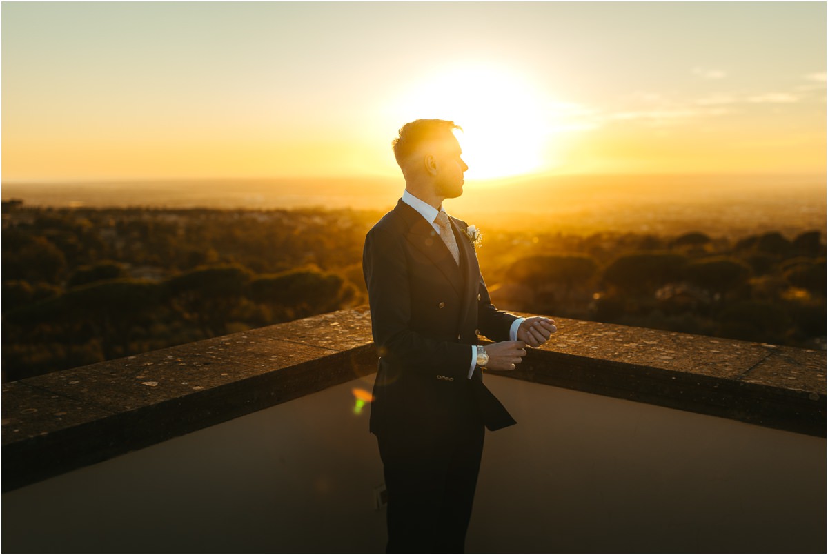 Groom Angus at Sunset Groom Angus in a double-breasted suit looking at the sunset from the terrace of Villa Grazioli