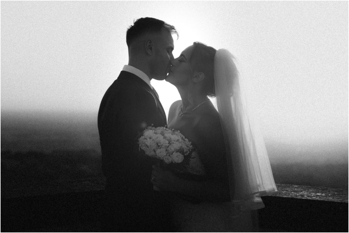 Backlit Kiss, Black and White Black and white backlit photo of Angus and Miriana kissing with her bouquet between them