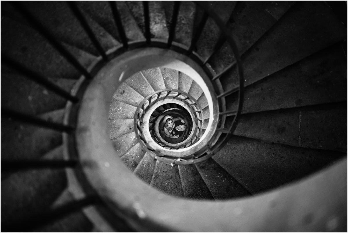 Couple at the Bottom of the Spiral Staircase Black and white view down a spiral staircase at Villa Grazioli with Miriana and Angus at the bottom
