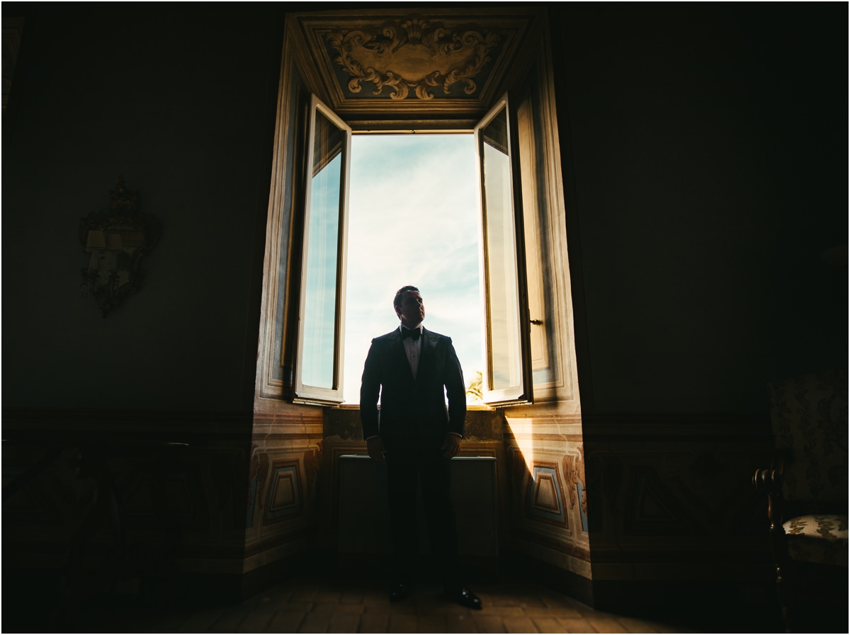 Groom in the Frescoed Hall Groom Alessio as a silhouette in front of a tall open window in a frescoed hall of Villa Grazioli