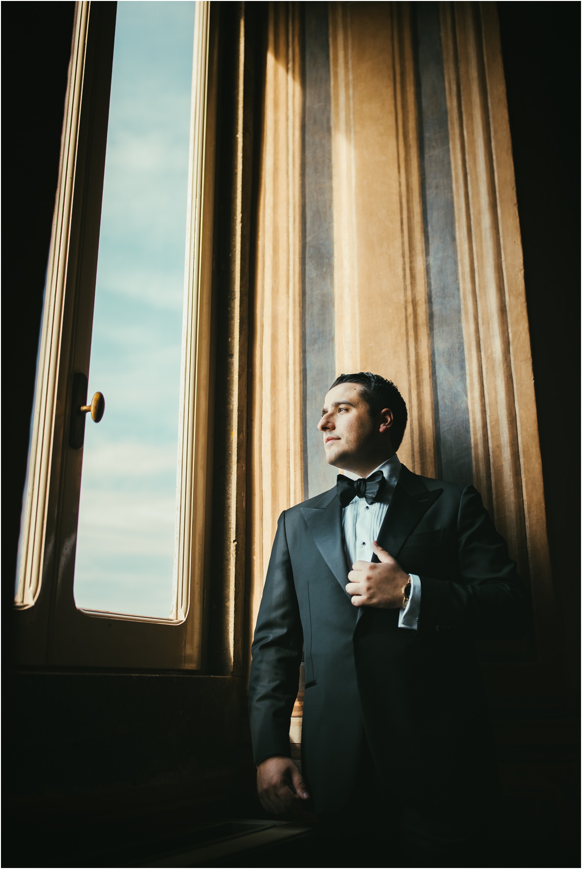 Groom Portrait by the Window Groom Alessio in black tuxedo lit by window light inside Villa Grazioli, Grottaferrata