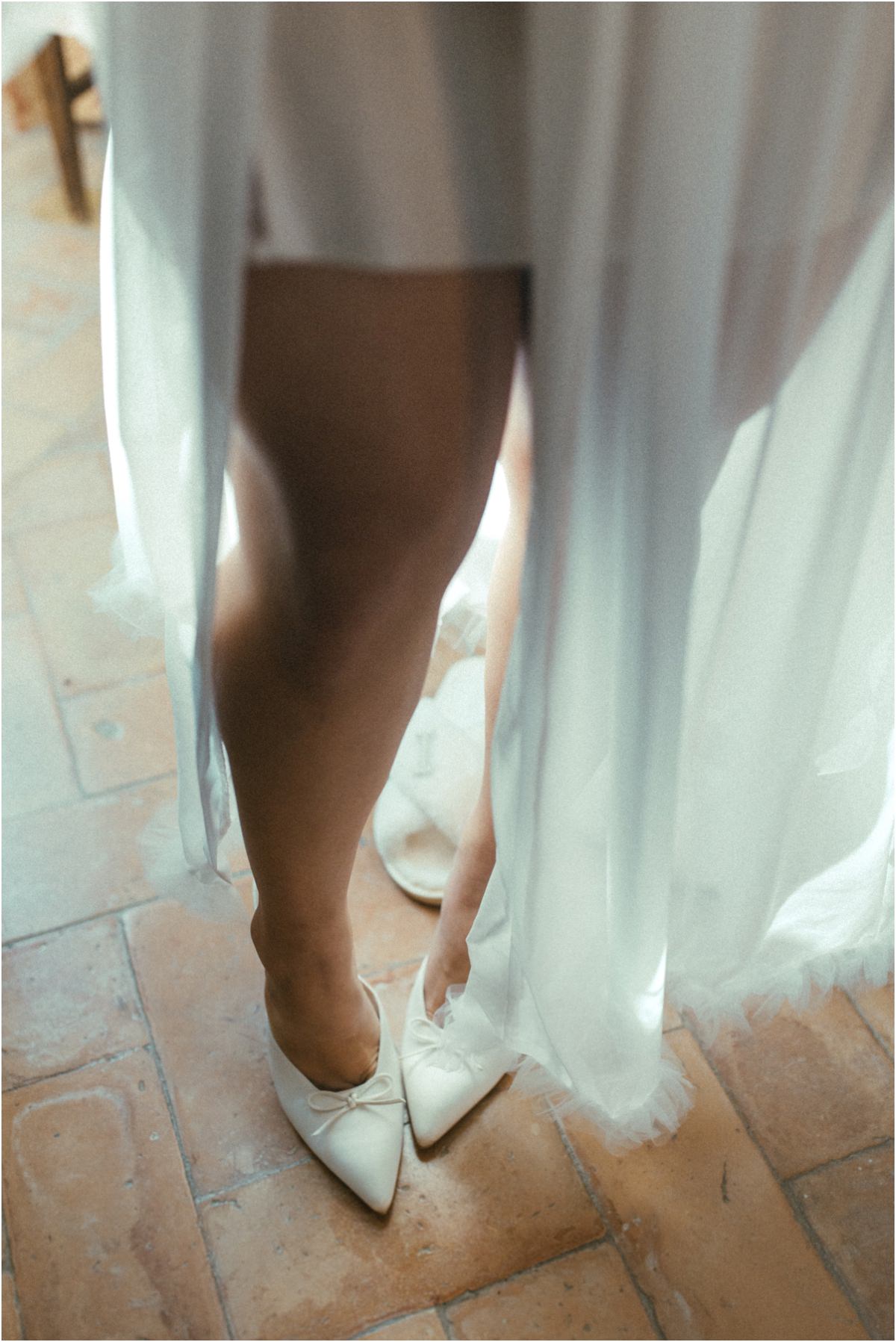 Bride's Shoes Detail of bride Leah slipping on white bow flats under her robe on the terracotta floor of Villa Grazioli