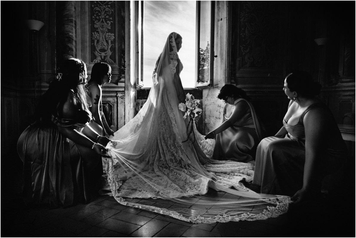 Preparing the Veil, Black and White Black and white photo of bridesmaids spreading the veil and train of bride Leah on the floor