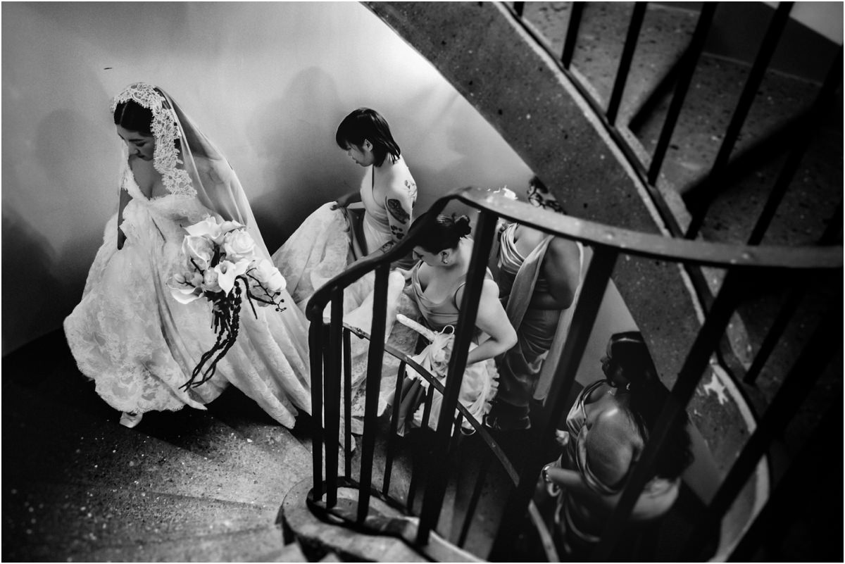 Down the Spiral Staircase Black and white photo of bride Leah walking down the spiral staircase of Villa Grazioli while bridesmaids hold her train