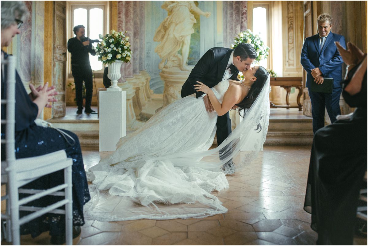The First Kiss Groom Alessio dipping bride Leah for the first kiss in the Pannini Gallery, guests applauding