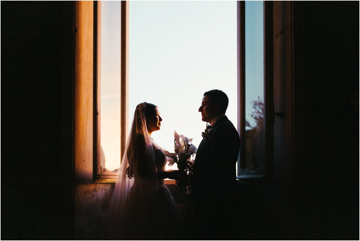 Silhouettes at the Window Silhouettes of Alessio and Leah facing each other at a tall window of Villa Grazioli in the evening light