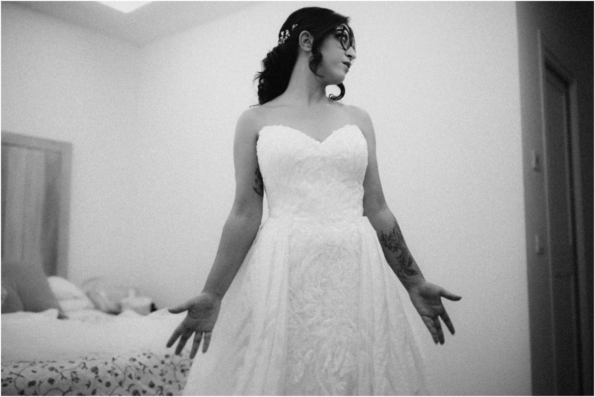 Eccola Martina in abito da sposa con le braccia aperte nella camera, foto in bianco e nero