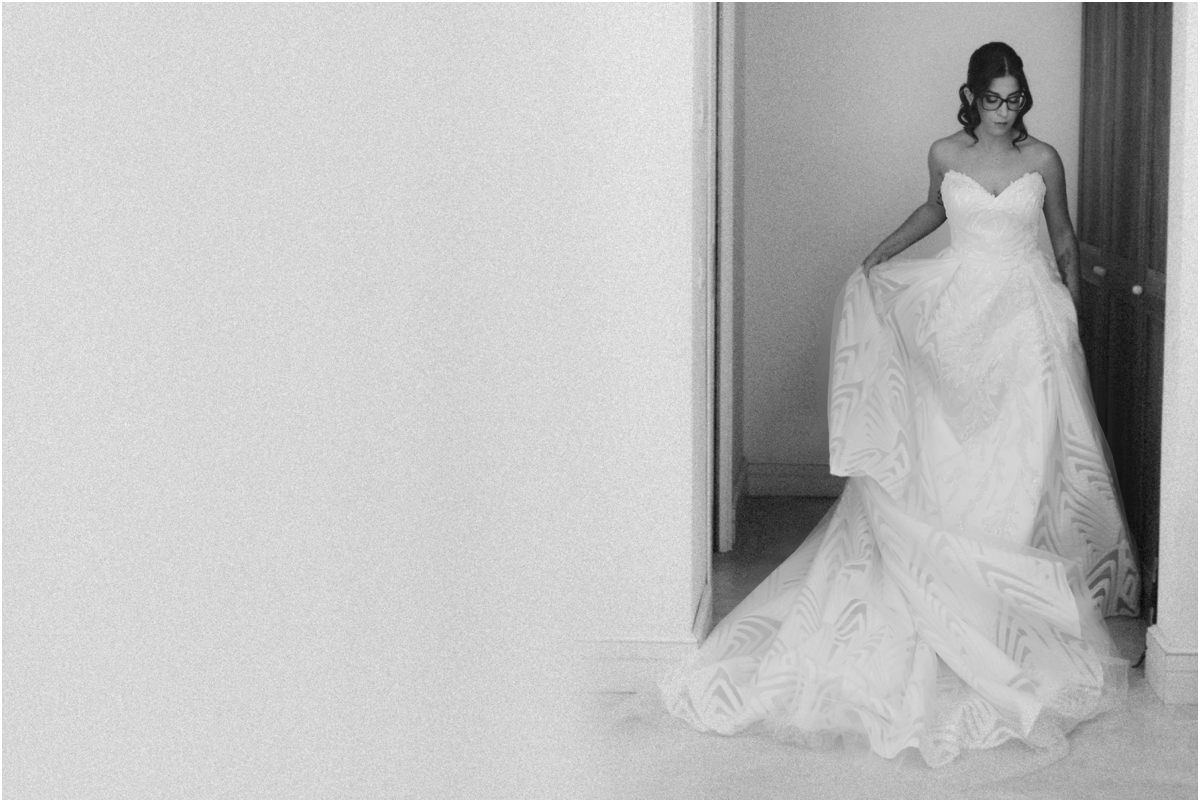 Lo strascico Martina esce dalla camera sollevando lo strascico dell'abito, foto in bianco e nero