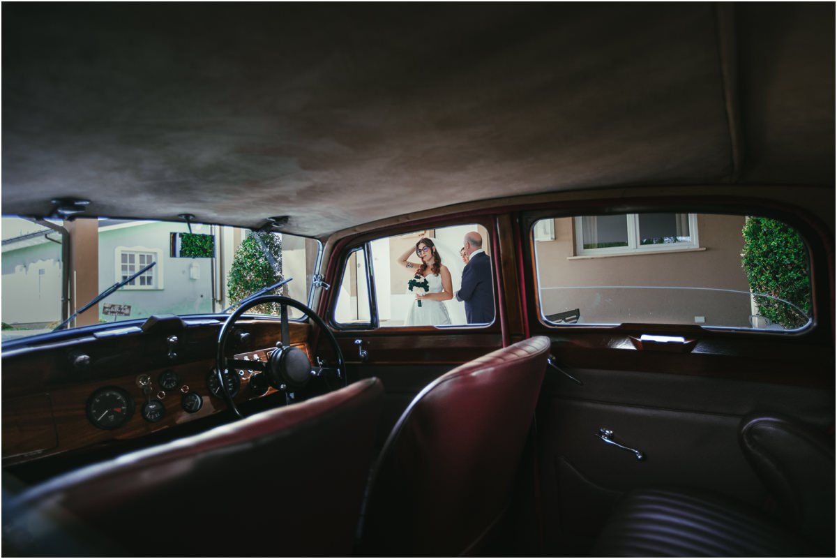 Dall'interno dell'auto Martina e il suo accompagnatore visti dall'interno dell'auto d'epoca con i sedili in pelle rossa