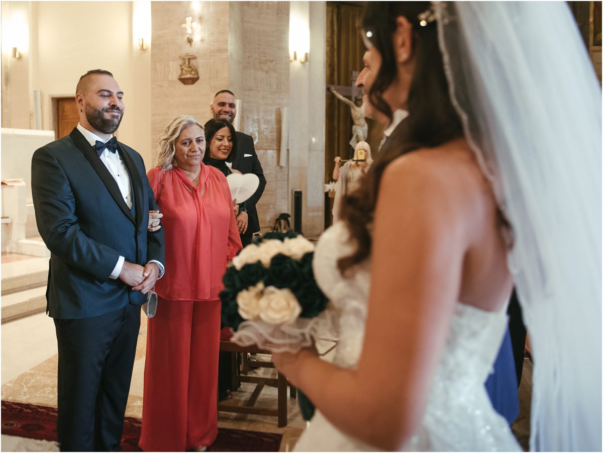 Eccola Davide sorride vedendo arrivare Martina con il bouquet verde e bianco all'altare