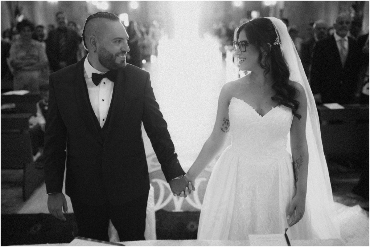 Mano nella mano Martina e Davide si prendono per mano all'altare, foto in bianco e nero