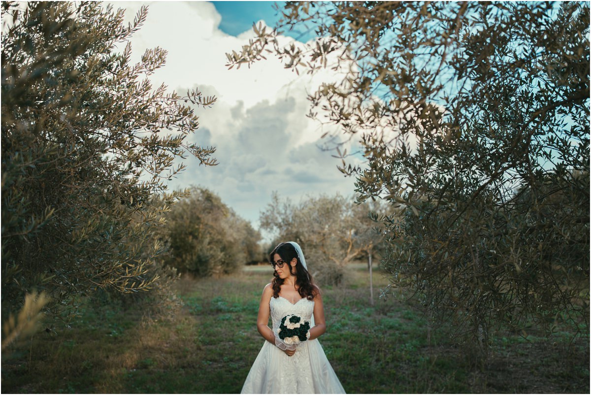 Martina Martina con il bouquet tra i rami degli ulivi, sotto un cielo di nuvole