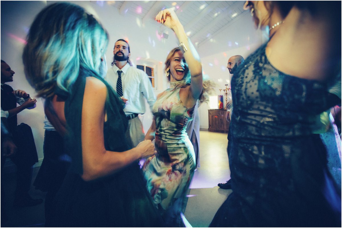 Le amiche Amiche che ballano con le braccia alzate sotto le luci colorate della festa