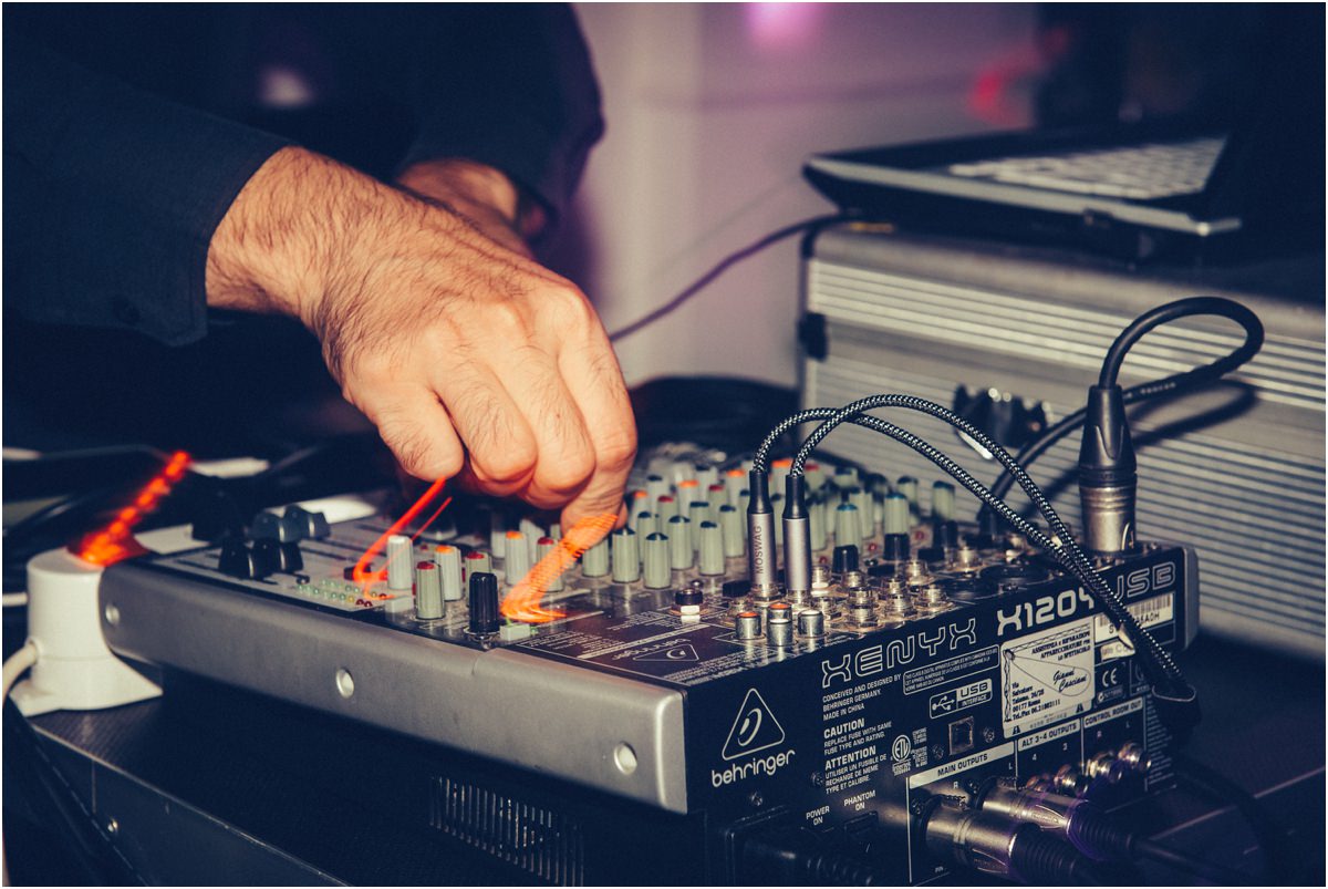 Il mixer Mano del dj sul mixer audio durante la festa di matrimonio a Le Jardin Potager