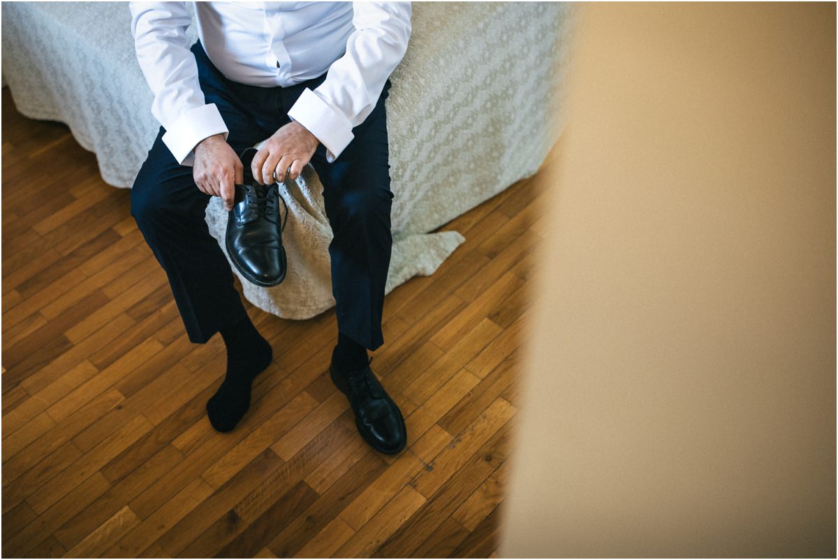 Giuseppe allaccia le scarpe Lo sposo Giuseppe allaccia le scarpe seduto sul letto