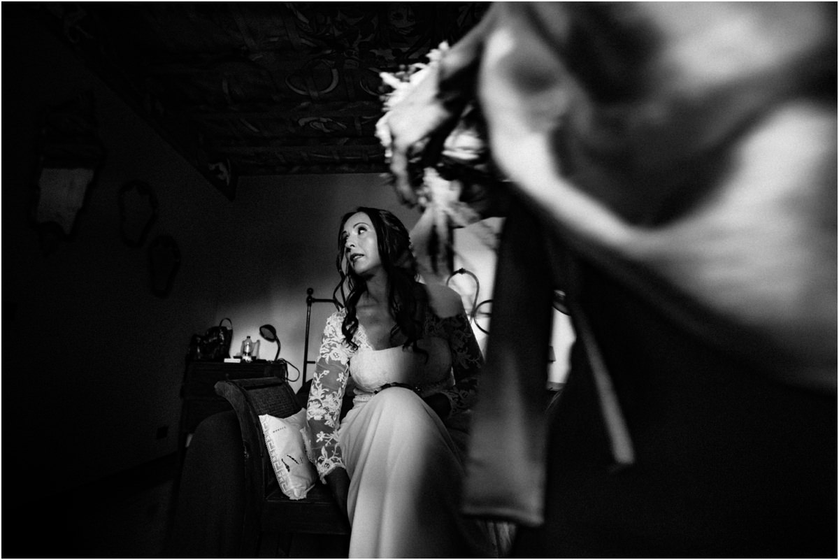 La sposa indossa le scarpe Cinzia seduta mentre indossa le scarpe, foto in bianco e nero