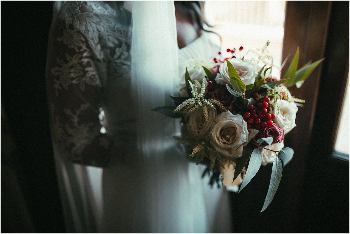 Bouquet della sposa Bouquet di rose e bacche accanto all'abito di pizzo