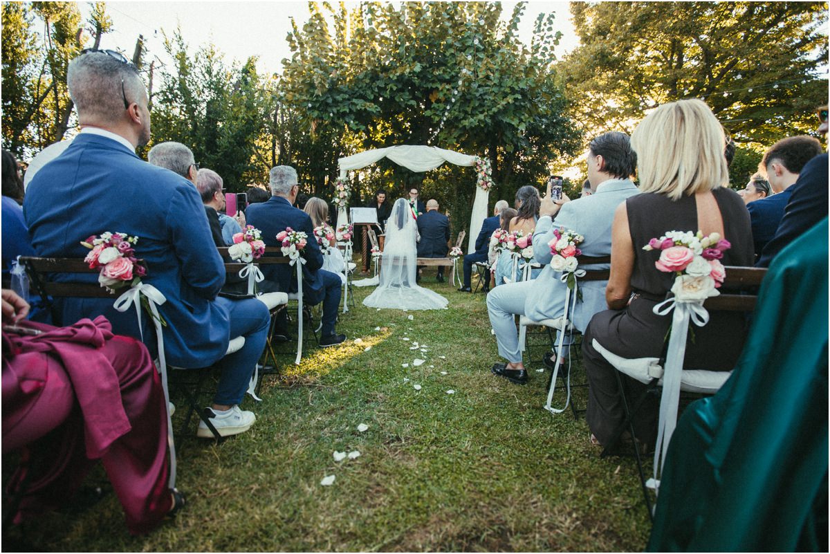 Inizio della cerimonia Gli invitati seduti nel giardino all'inizio della cerimonia