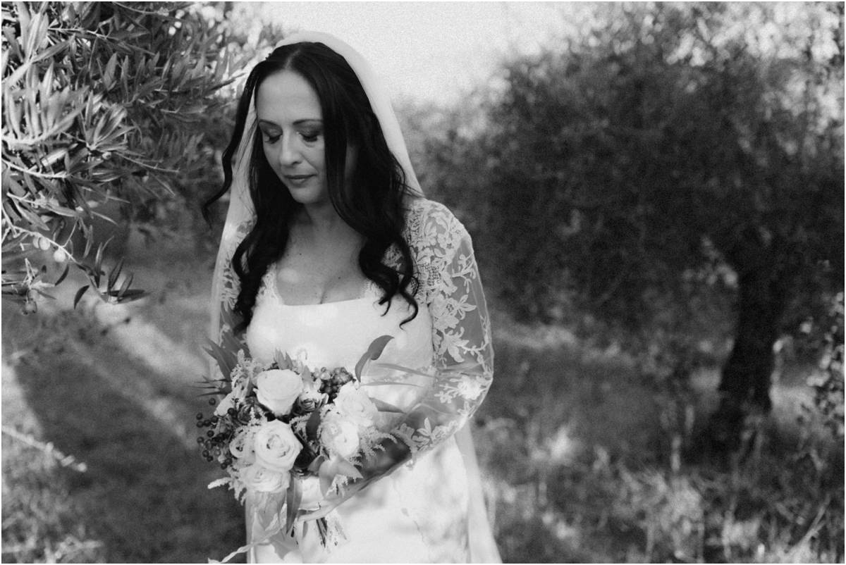 La sposa e il bouquet Cinzia guarda il bouquet tra gli ulivi, foto in bianco e nero
