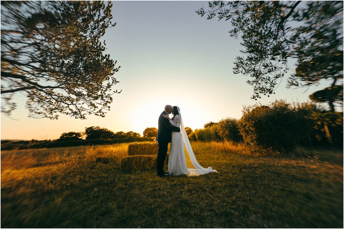 Bacio al tramonto Bacio degli sposi nel prato al tramonto