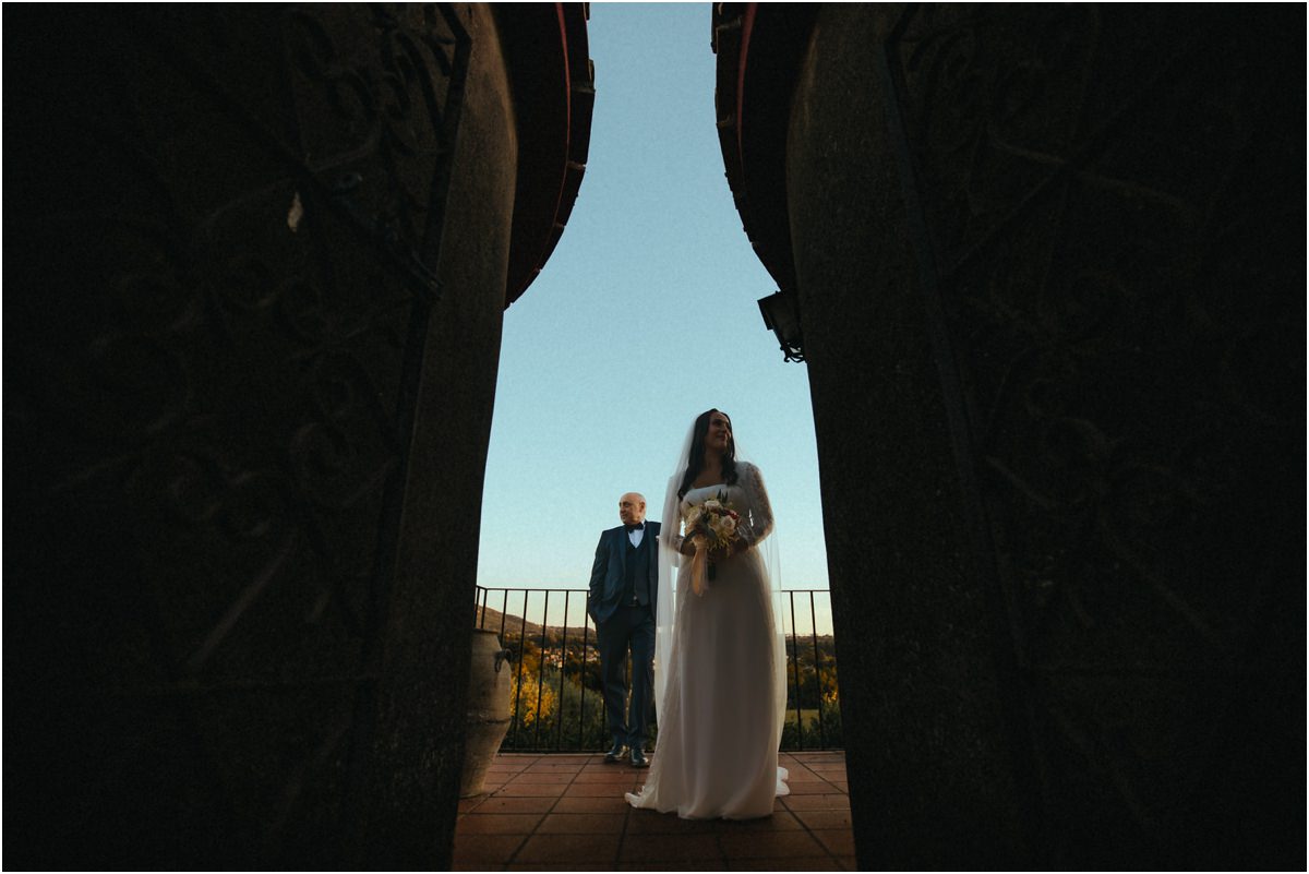 Gli sposi all'ultima luce Cinzia e Giuseppe sulla terrazza visti dalla porta all'ultima luce