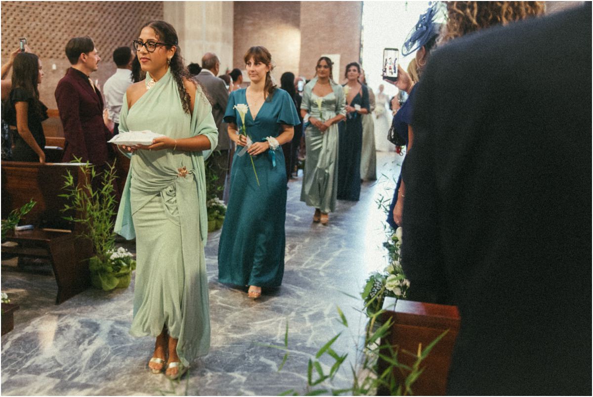 Sorella della sposa con le fedi Ingresso in chiesa della sorella della sposa con le fedi e delle amiche in abiti verdi