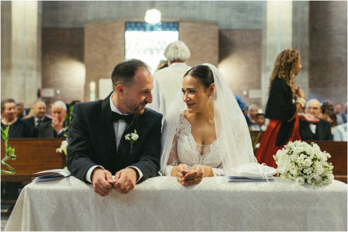 Sposi all'altare, sorrisi Alice e Valerio seduti all'altare si sorridono