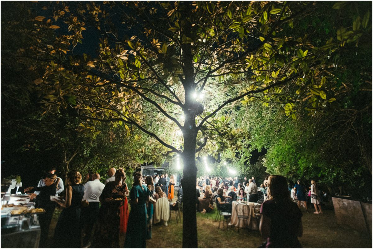 Aperitivo a Villa Parco Iris Aperitivo degli invitati sotto gli alberi illuminati di Villa Parco Iris